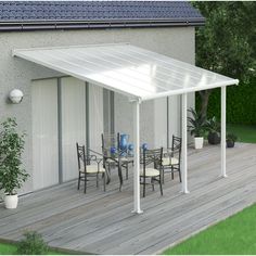 an outdoor patio with table and chairs under a white awning