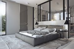 a large bed sitting in the middle of a bedroom next to a tall mirror wall