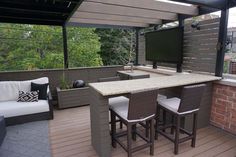 an outdoor living area with bar and seating