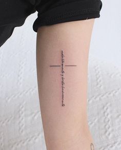 a woman's arm with a cross tattoo on the left side of her arm