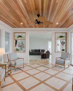 a living room filled with furniture and a ceiling fan in the middle of an open floor plan