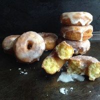 a pile of doughnuts sitting on top of a wooden table