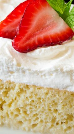 a piece of cake with white frosting and strawberries on top