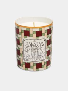 a candle that is sitting in front of a white background and green checkered pattern