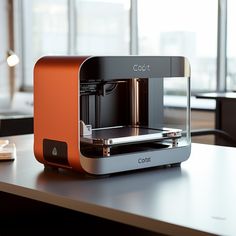 an orange and black 3d printer sitting on top of a table