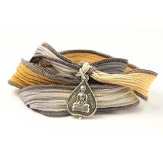 three bracelets with silver buddha charms on top of each one and two different colored cords