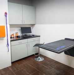 a kitchen with a table and cabinets in it, next to a laptop on the counter