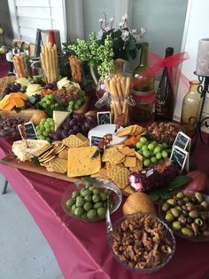 a table topped with lots of different types of cheese and crackers next to bottles of wine