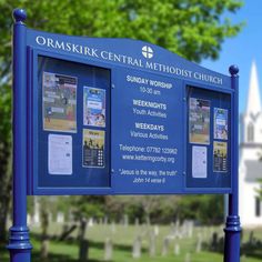 a blue sign sitting in front of a cemetery