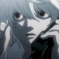 an anime character holding a cell phone up to his ear and looking at the camera