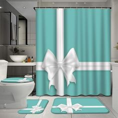 a bathroom with blue and white shower curtains, rugs and bath mats in the shape of bows