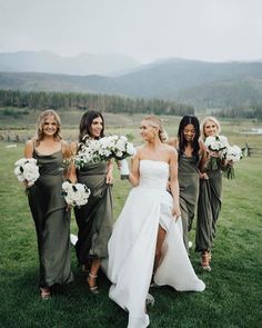 a group of women standing next to each other on top of a lush green field