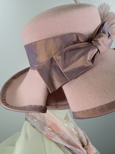 You'll look great in this pretty pink wool felt hat! It can easily transition from Winter to early Spring and is perfect for any dressy occasion. Imagine walking into church with this beauty! The flattering asymmetrical wide brim hat turns up on the left and slopes down on the right. A unique folded pleat adorns the brim. It's topped with a gorgeous mauve/pink band and bow. This hat that will be the envy of everyone who see it! The hat itself is pink wool felt and the crown (top) is slightly dom Fitted Wide Brim Felt Hat For Spring, Fitted Wool Party Hat, Spring Fitted Wide Brim Felt Hat, Fitted Beige Cloche Hat For Church, Pink Brimmed Cloche Hat, Wool Cloche Hat For Party, Spring Fitted Wool Felt Hat, Fitted Cloche Hat For Evening In Spring, Spring Wool Felt Hat