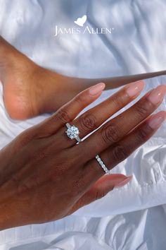 a woman's hand holding a diamond ring