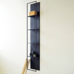 a baseball bat leaning against the wall next to a book shelf with books on it