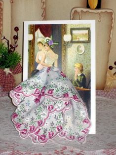 there is a card with an image of a woman in a dress on the table