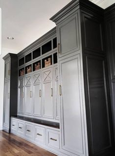 an empty room with gray cabinets and wood floors