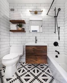 a bathroom with black and white floor tiles, a toilet, sink and bathtub