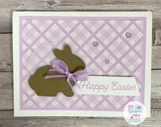 a happy easter card with a brown bunny on it's side and a purple ribbon around the corner