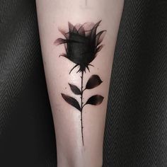 a black rose tattoo on the leg