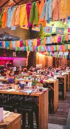 colorful streamers hang from the ceiling above tables in a restaurant decorated for a party