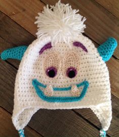 a crocheted hat with a smiling face on it