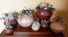 several decorative vases are sitting on top of a wooden table, decorated with bows and ribbons