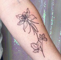 a woman's arm with a flower tattoo on it