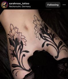 a woman's stomach with flowers on it and black lace around the breast area