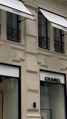 the storefront of a chanel boutique with an umbrella over it's windows