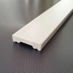 a close up of a white plastic strip on a table with black dots patterning