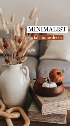 a white vase sitting on top of a wooden table next to a pile of books