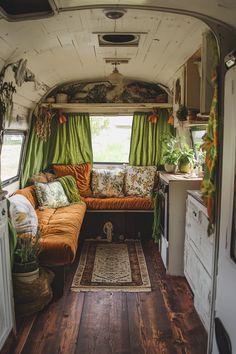 the interior of an old camper with green curtains and pillows on it's windowsill