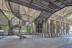 the inside of a building with many metal pipes and spiral staircases on each side