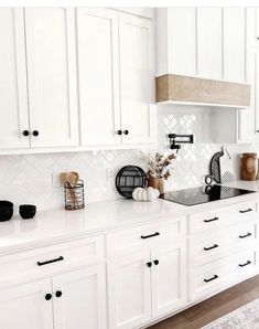 a kitchen with white cabinets and black appliances