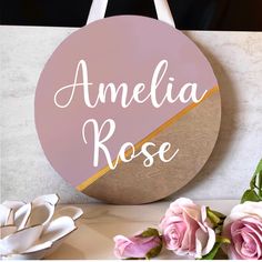 a sign that says amelie rose on it next to some pink roses and white flowers