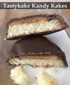 two pieces of chocolate covered pastry sitting on top of a white plate with the words tastyke kandy kakes