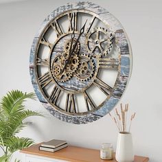 a clock that is on the wall next to a potted plant and some books