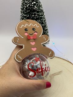 a hand holding a glass ornament with a ginger on it