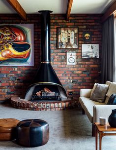 a living room filled with furniture and a fire place in the middle of it's wall