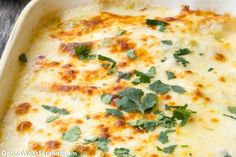 a casserole dish with cheese and parsley on top, ready to be eaten