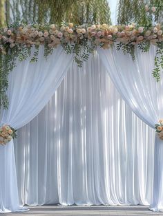 an outdoor ceremony with white drapes and flowers