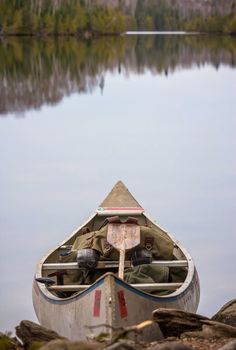 a canoe sitting on the shore of a lake