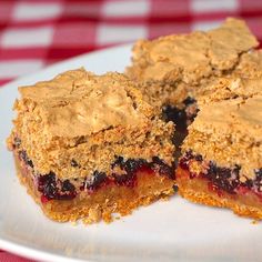 two pieces of blueberry pie on a white plate with a red and white checkered tablecloth