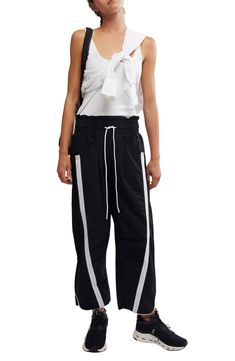 Traditionally sporty track attire gets a street-style reset in these water-resistant nylon pants refreshed with an ultrawide smocked waistband and wavy cropped hems. 25 1/2" inseam; 18" leg opening; 14" front rise; 18" back rise (size Medium) Smocked/drawstring waist Front scoop pockets; back patch pockets Water resistant 100% nylon Machine wash, tumble dry Imported Sporty Baggy Parachute Pants With Drawstring, Sporty Parachute Pants With Functional Drawstring For Spring, Sporty Cotton Parachute Pants, Sporty Wide Leg Nylon Sweatpants, Sporty Wide-leg Sweatpants, Sporty Stretch Parachute Pants With Drawstring, Sporty Nylon Sweatpants With Drawstring, Athleisure Parachute Pants With Functional Drawstring, Sporty Stretch Parachute Pants With Elastic Side Panels