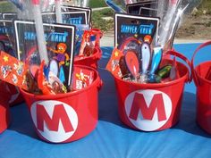 red buckets filled with toothbrushes and magnets on top of a blue table