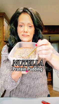 a woman holding a bowl of food in front of her face with the words nutella protein pudding on it