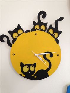 a yellow clock with black cats on it's face and numbers in the middle