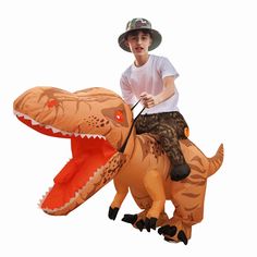 a young boy riding on the back of an inflatable t - rexe