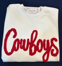 This listing is for 1 custom chenille yarn embroidered sweatshirt.  We can do several different color combinations.  This listing is for the word Cowboys only. You can change your colors but this listing is not for a new  word.  When checking out please leave the color combination wanted.   We do not recommend doing white chenille yarn on black sweatshirts.  Machine wash cold, do not soak or bleach. For best results dry flat, but I do dry mine on low. Do not iron the chenille; it will melt. For Game Day White Sweatshirt With Embroidered Graphics, White Game Day Sweatshirt With Embroidered Graphics, White Team Spirit Sweatshirt With Embroidered Graphics, White Collegiate Sweatshirt With Letter Embroidery, White Sweatshirt With Embroidered Graphics For Team Spirit, White Custom Embroidery Sweatshirt For School Spirit, White School Spirit Sweatshirt With Embroidered Text, White School Spirit Sweatshirt With Letter Embroidery, White Embroidered Logo Sweatshirt For Game Day